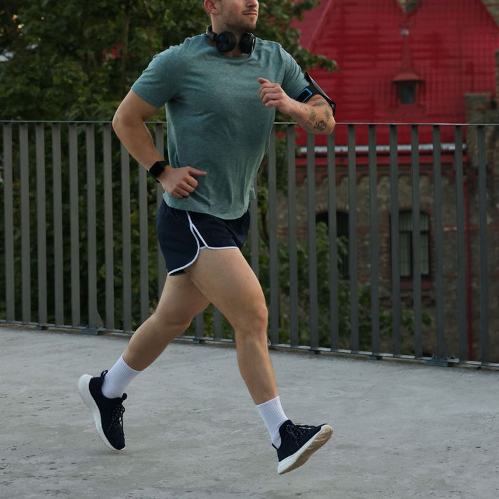Man running outdoors on a paved path with a blurred background