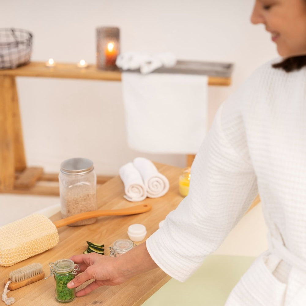 Person in a kitchen setting with jars and a wooden table.